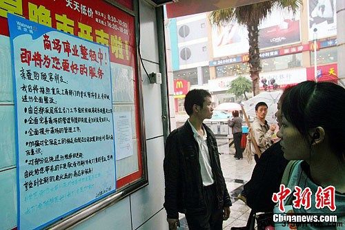 10月11日,重慶市民在萬州沃爾瑪太白路分店超市門口關(guān)注停業(yè)整頓公告。近日,因涉銷售假冒“綠色豬肉”,沃爾瑪在渝13家門店被當(dāng)?shù)毓ど滩块T責(zé)令停業(yè)整頓15天。中新社發(fā) 趙俊超 攝