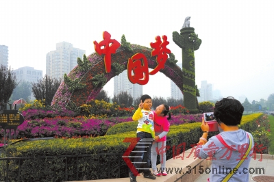 市民在復(fù)興門橋“放飛夢(mèng)想”花壇前留念。昨天,長(zhǎng)安街沿線花壇擺放工作全部完成。京華時(shí)報(bào)記者徐曉帆攝